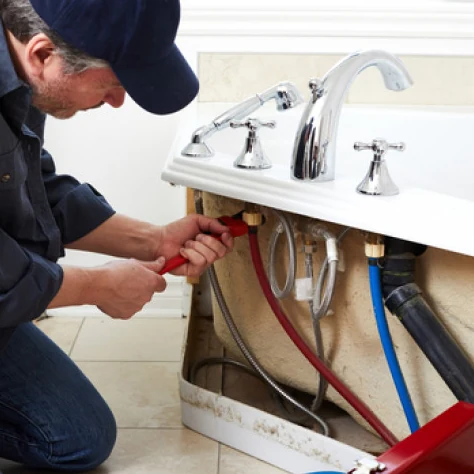 Plumber servicing residential water-heating equipment